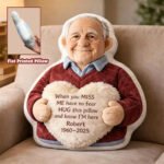 "Custom memorial pillow shaped like an elderly man holding a heart cushion with a personalized message and name, displayed on a sofa with an inset showing the flat printed pillow design