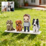Custom brick figures of a man with three pets (cat and two dogs) displayed on a base outdoors, with a reference photo of the owner and pets shown in the corner.