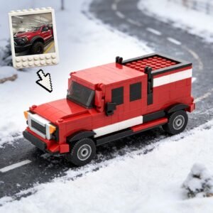Custom red truck model made from building blocks, placed on a snowy road. A photo of the real truck version is shown above the model with an arrow pointing to it