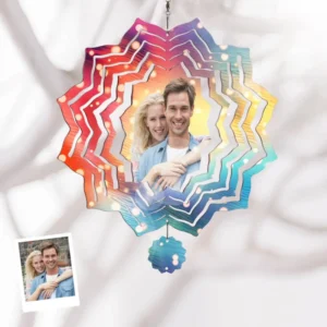 Personalized snowflake wind spinner with colorful gradient layers featuring a couple’s photo in the center, hanging against a soft fabric background
