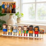 Custom brick figure family set displayed on a base, inspired by a group family photo shown in the corner, placed on a table in a bright home interior