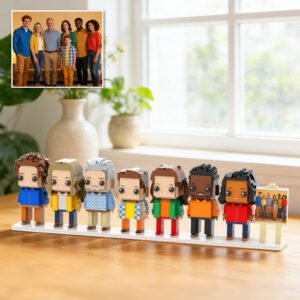 Custom brick figure family set displayed on a base, inspired by a group family photo shown in the corner, placed on a table in a bright home interior