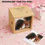 Personalized wooden photo cube music box engraved with a custom message and date, featuring a rotating couple photo and an additional printed photo placed beside it